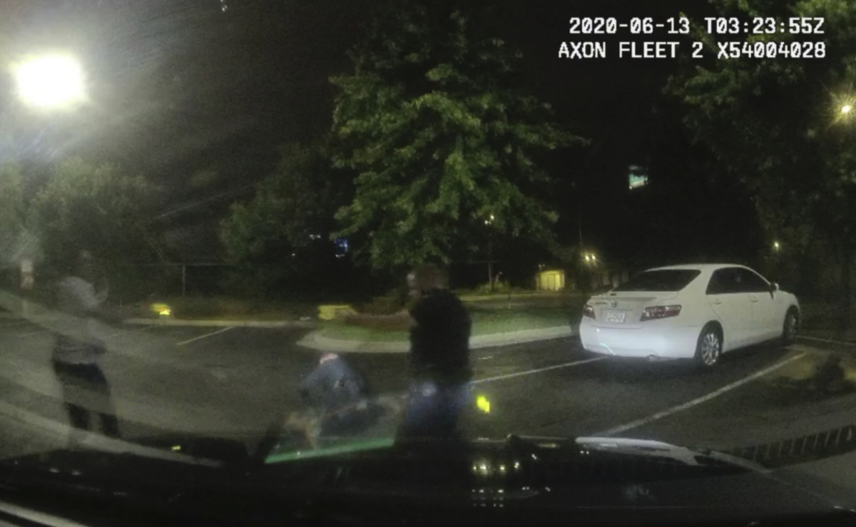This screengrab taken from dashboard camera video provided by the Atlanta Police Department shows Rayshard Brooks (L) and Officer Garrett Rolfe pointing Tasers at one another, while Officer Devin Brosnan is seen getting up after a struggle among the three men in the parking lot of a Wendy's restaurant in Atlanta, Ga., overnight June 13, 2020. (Atlanta Police Department via AP)