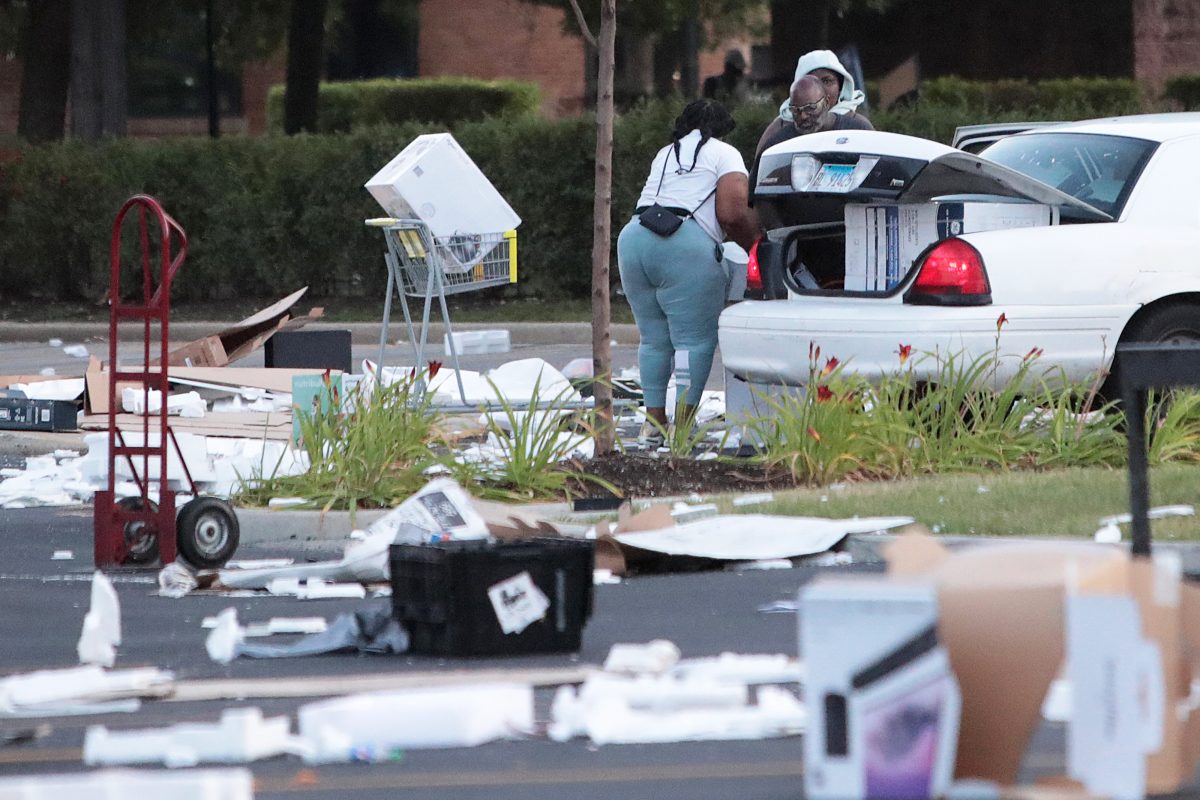 People load merchandise into a car near a looted Best Buy store after parts of the city had widespread looting and vandalism in Chicago, on Aug. 10, 2020. (Scott Olson/Getty Images)
