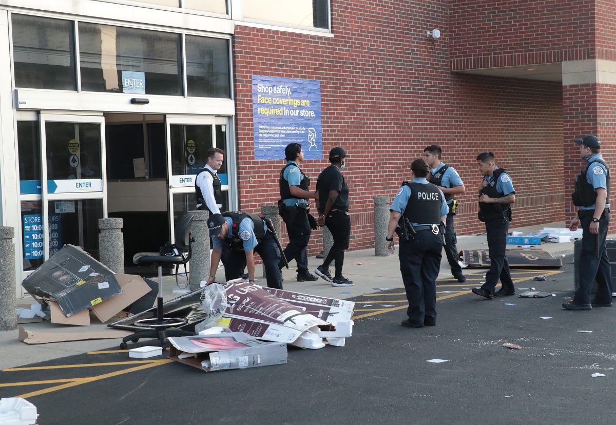 Police officers detain a man who was found inside of a Best Buy store after parts of the city had widespread looting and vandalism in Chicago, on Aug. 10, 2020. (Scott Olson/Getty Images)
