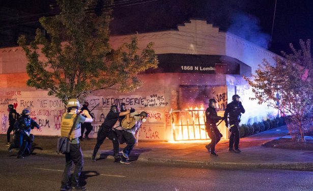 Portland police disperse a crowd after protesters set fire to the Portland Police Association (PPA) building early in the morning in Portland, Ore., on Aug. 29, 2020. (Nathan Howard/Getty Images)