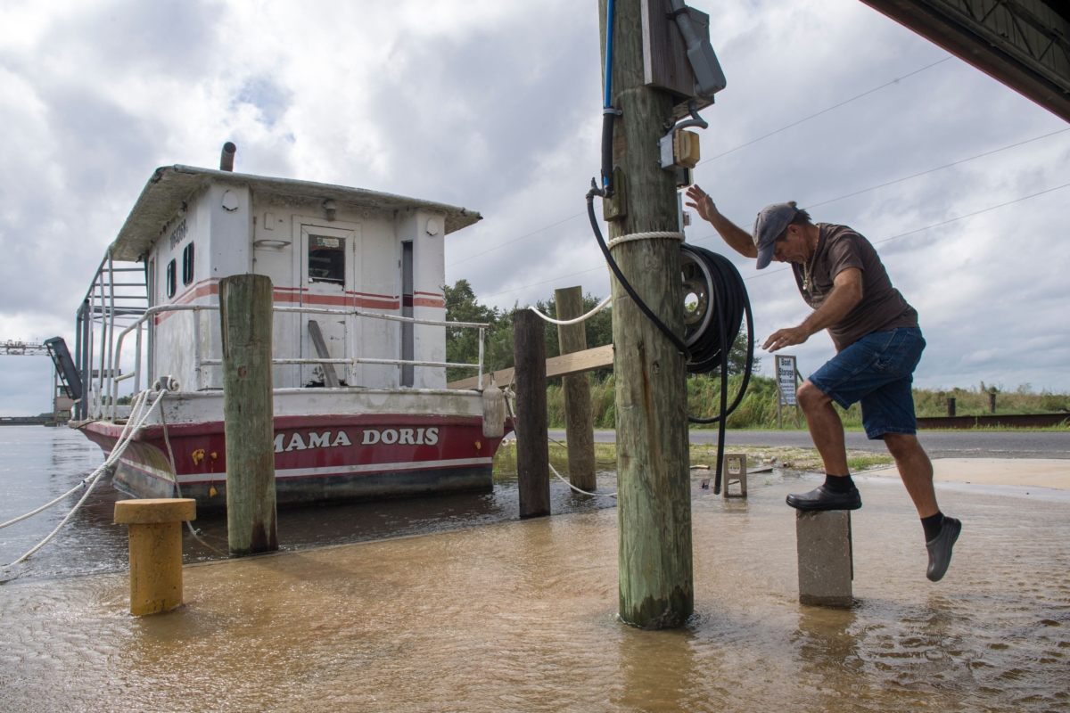 Don Robin stands on a concrete block as the water rises as Hurricane Sally heads toward the Gulf Coast in eastern St. Bernard Parish, La., on Sept. 14, 2020. (Chris Granger/The Advocate via AP)