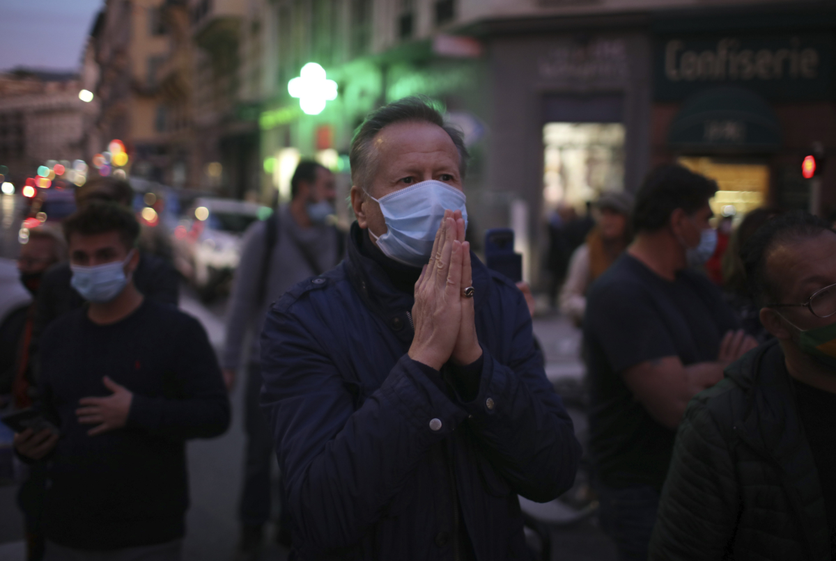 A man prays in the street outside the Notre Dame church after a knife attack took place in Nice, southern France, on Oct. 29, 2020. (Daniel Cole/AP Photo)