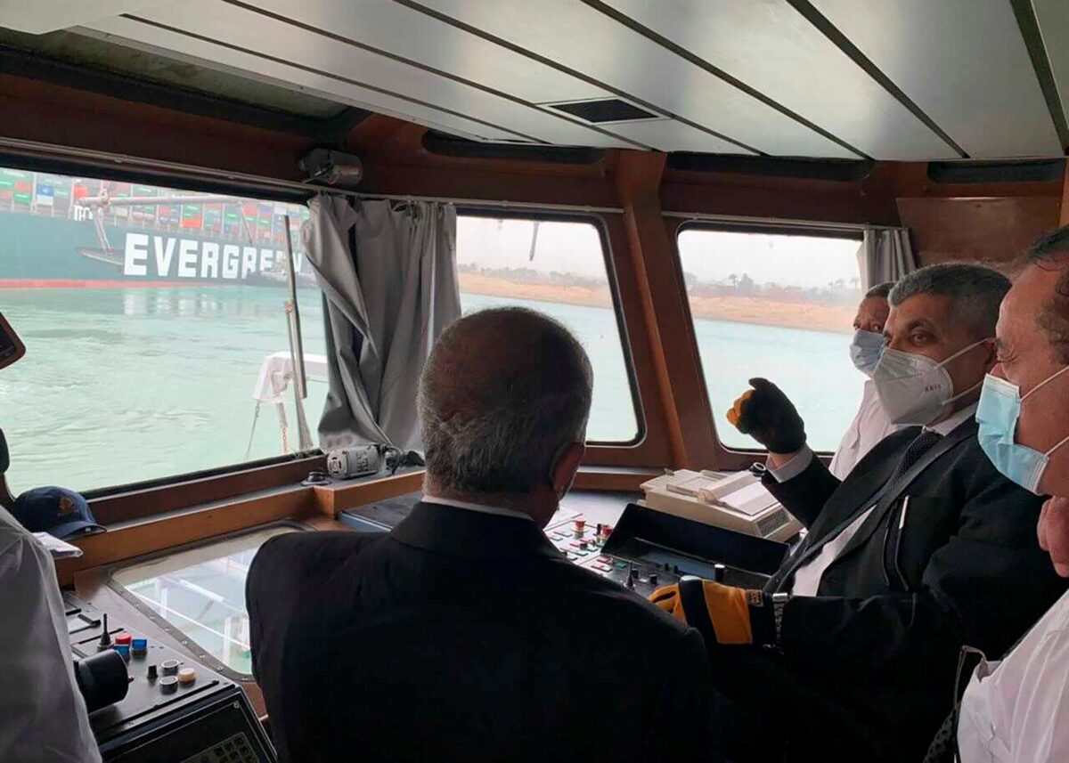 Lt. Gen. Ossama Rabei, head of the Suez Canal Authority, second right, speaks to other staff onboard a boat near the stuck cargo ship MV Ever Given near Suez, Egypt, on March 24, 2021. (Suez Canal Authority via AP)