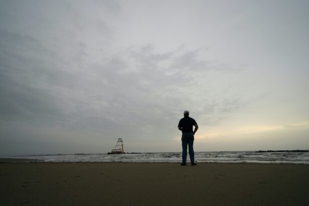 A man who did not want to be identified surveys his company's barge that ran aground during a storm on Tuesday, that also capsized a lift boat, in the Gulf of Mexico, in Grand Isle, La., on Thursday, April 15, 2021. (Gerald Herbert/AP Photo)