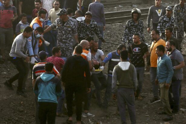 Medics carry an injured man at the site where a passenger train derailed injuring at least 98 people, in Banha, Qalyubia province, Egypt, on April 18, 2021. (Fadel Dawood/AP Photo)