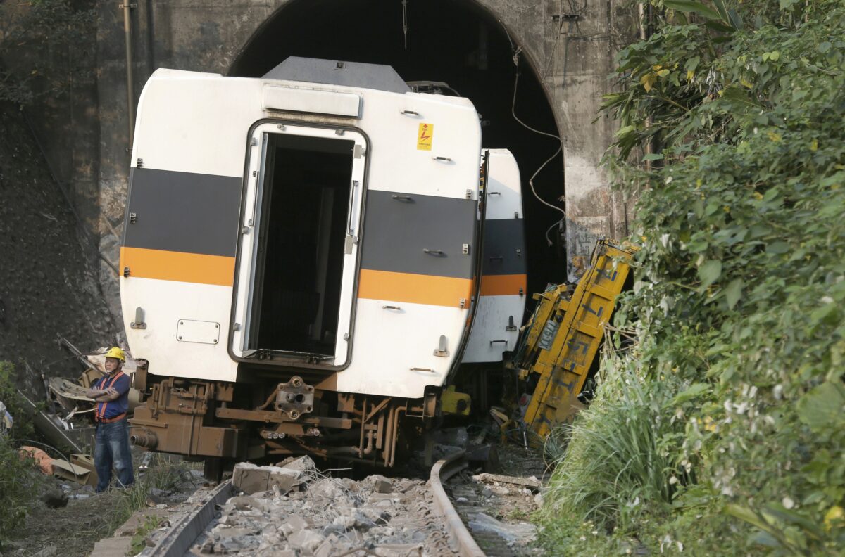 A worker stands in front of the derailed train near Taroko Gorge in Hualien, Taiwan, on April 3, 2021. (Chiang Ying-ying/AP Photo)