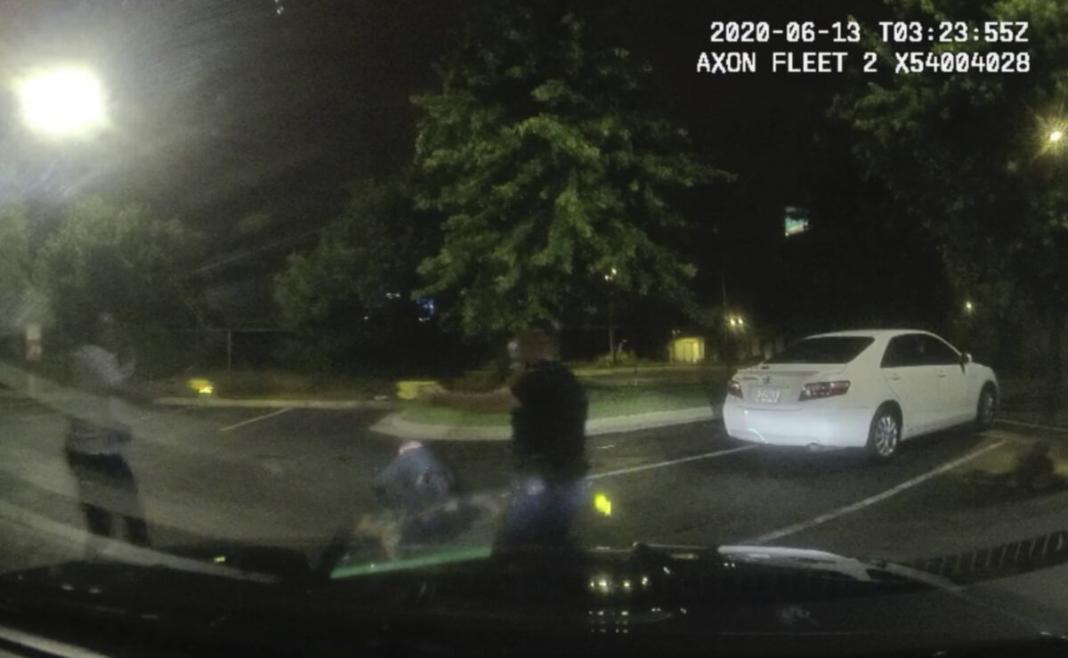This screen grab taken from dashboard camera video provided by the Atlanta Police Department shows Rayshard Brooks, left, and Officer Garrett Rolfe pointing Tasers at one another, while Officer Devin Brosnan is seen getting up after a struggle among the three men in the parking lot of a Wendy's restaurant, in Atlanta, Ga., early June 13, 2020. (Atlanta Police Department via AP)