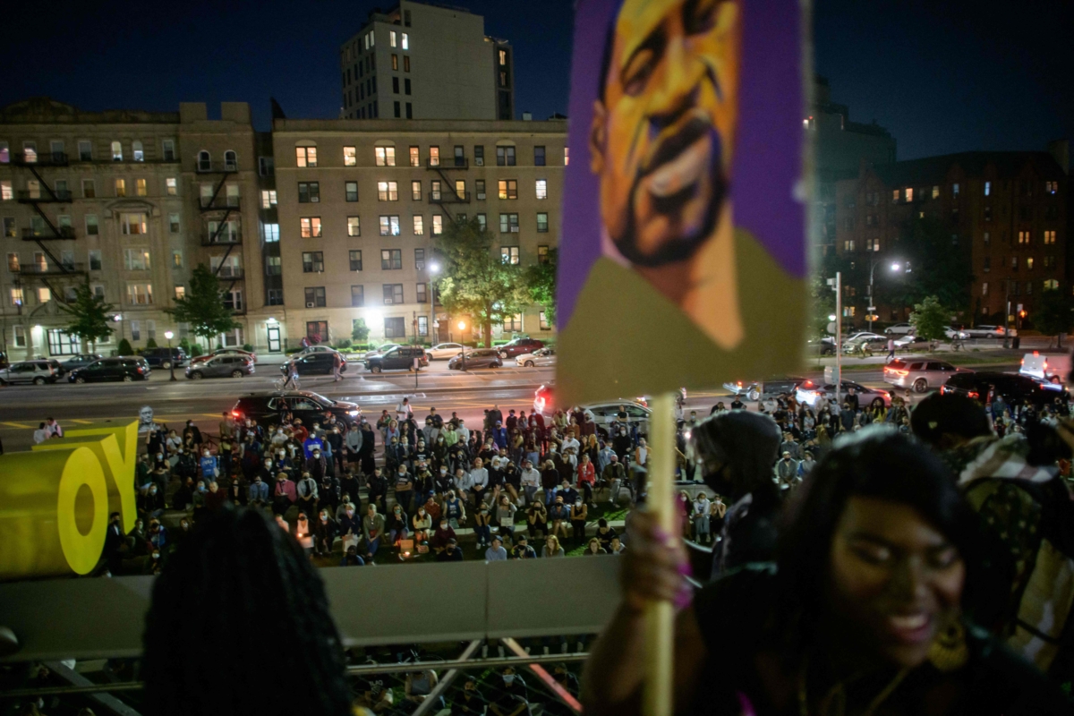 Black Lives Matter (BLM) protesters hold placards during a vigil on the anniversary of the death of George Floyd, in Brooklyn, N.Y., on May 25, 2021. (Ed Jones/AFP via Getty Images)