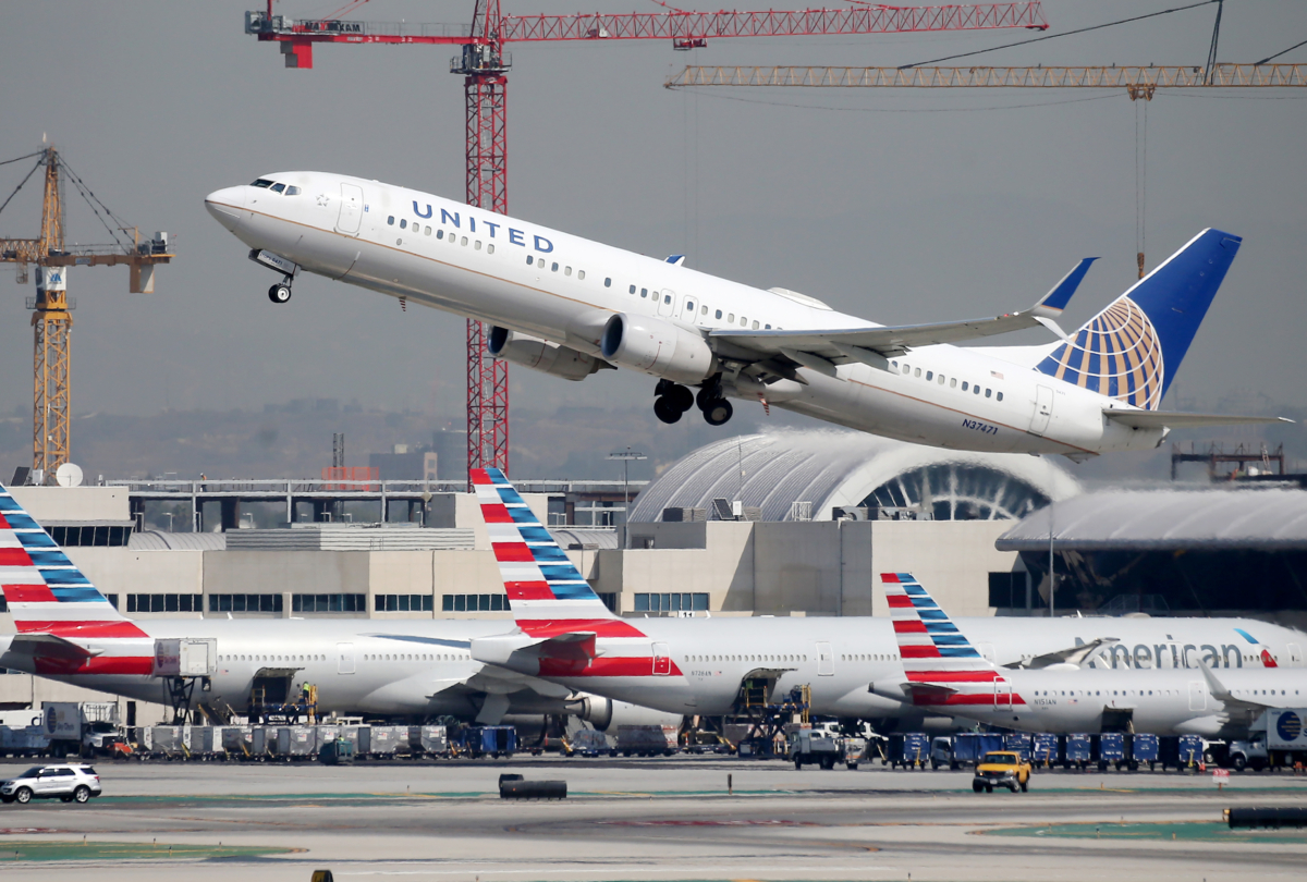 A United Airlines plane takes off above American Airlines planes on the tarmac at Los Angeles International Airport (LAX) in Los Angeles, Calif., on Oct. 1, 2020. (Mario Tama/Getty Images)