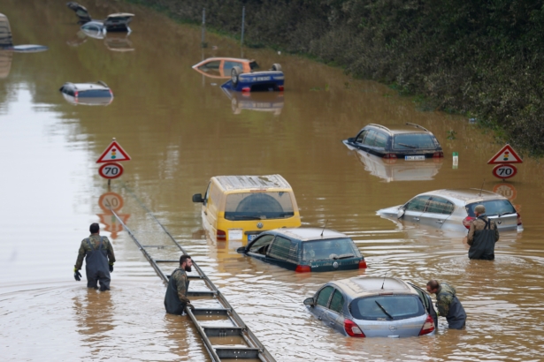 Members of the Bundeswehr forces, surrounded by partially submerged cars, wade through the flood water following heavy rainfalls in Erftstadt-Blessem, Germany, on July 17, 2021. (Thilo Schmuelgen /Reuters)