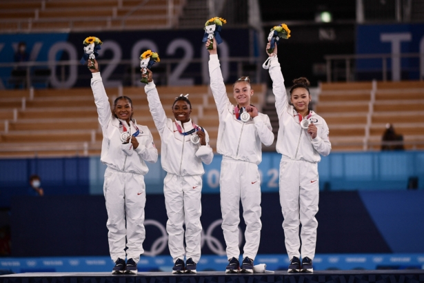 USA's Sunisa Lee, USA's Grace Mc Callum, USA's Simone Biles, and USA's Jordan Chiles wave on the podium of the artistic gymnastics women's team final after winning silver during the Tokyo Olympics in Tokyo, Japan, on July 27, 2021. (Loic Venance/AFP via Getty Images)