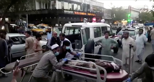 A screengrab shows people carrying an injured person to a hospital after an attack at Kabul airport, in Kabul, Afghanistan on Aug. 26, 2021. (Reuters TV/1TV via Reuters)