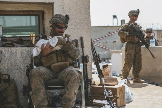 A Marine assigned to the 24th Marine Expeditionary Unit (MEU) calms an infant during an evacuation at Hamid Karzai International Airport, in Kabul, Afghanistan, on Aug. 20, 2021. (Sgt. Isaiah Campbell/U.S. Marine Corps via AP)