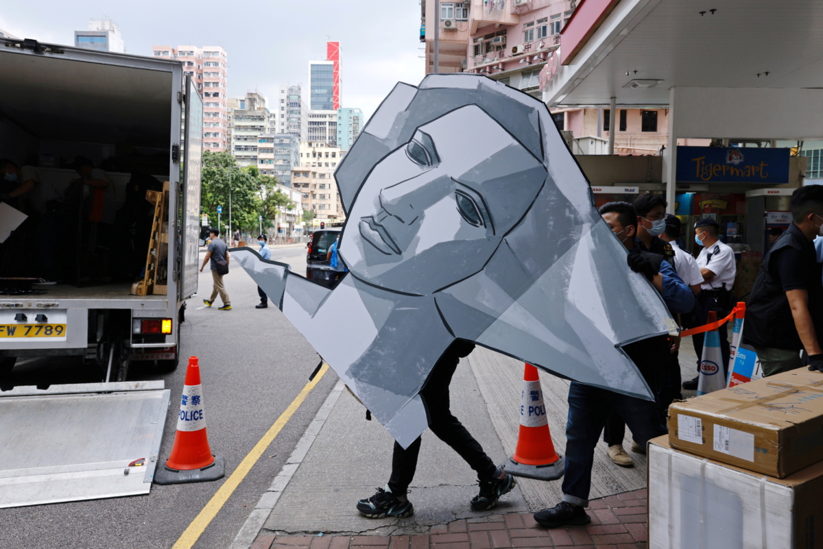 Police collect a cut out of the Goddess of Democracy at the June 4th Museum, which commemorates the 1989 Tiananmen Square crackdown, as they search the museum after arresting four members of the Hong Kong Alliance in Support of Patriotic Democratic Movements in China, in Hong Kong, China, on Sept. 9, 2021. (Tyrone Siu/Reuters)