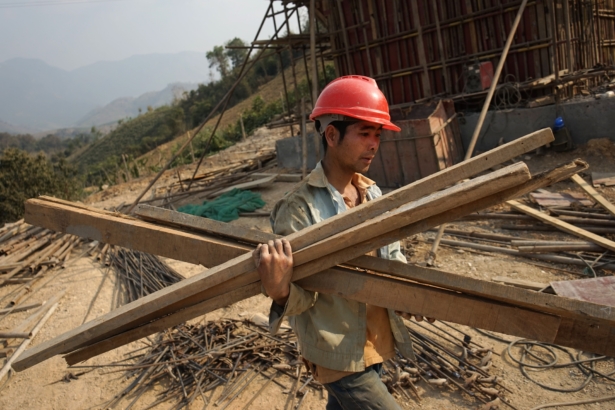 A Chinese worker carries materials for the first rail line linking China to Laos, a key part of Beijing's "Belt and Road" project across the Mekong in Luang Prabang, Laos, on Feb. 8, 2020. (Aidan Jones/AFP via Getty Images)