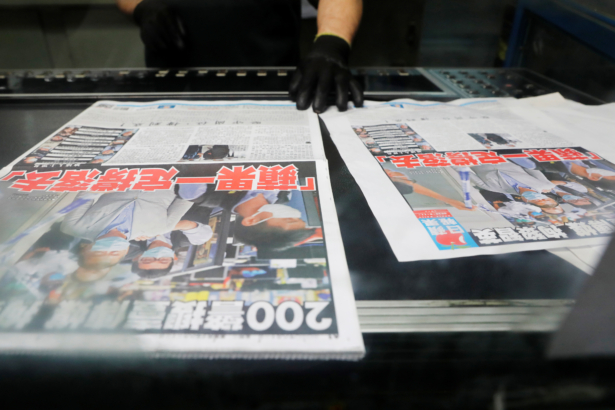 An employee checks the print quality of copies of the Apple Daily newspaper, published by Next Media Ltd, with a headline "Apple Daily will fight on" after media mogul Jimmy Lai Chee-ying, founder of Apple Daily was arrested by the national security unit, at the company's printing facility in Hong Kong, on Aug. 11, 2020. (Tyrone Siu/Reuters)