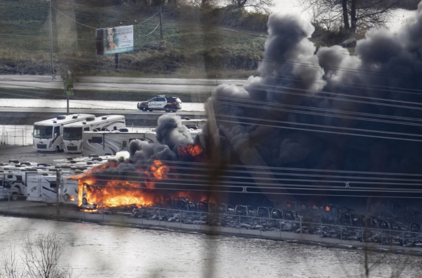 Recreational vehicles burn during a fire at a business surrounded by floodwaters in Abbotsford, British Columbia, on Nov. 17, 2021. (Darryl Dyck/The Canadian Press via AP)