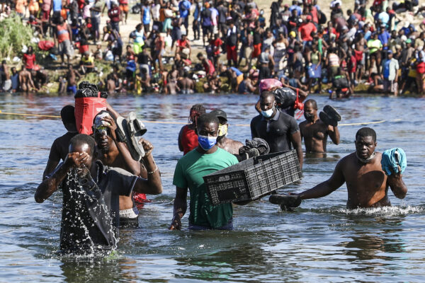Illegal immigrants cross the Rio Grande between Del Rio (far side) and Acuña, Mexico. Some are crossing back to Mexico to avoid deportation from the United States, in Acuña, Mexico, Sept. 20, 2021. (Charlotte Cuthbertson/The Epoch Times)