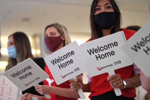 Qantas staff welcome the passengers of Los Angeles flight at the arrival gates of the Sydney International airport, on Nov. 1, 2021. (Saeed Khan/AFP via Getty Images)