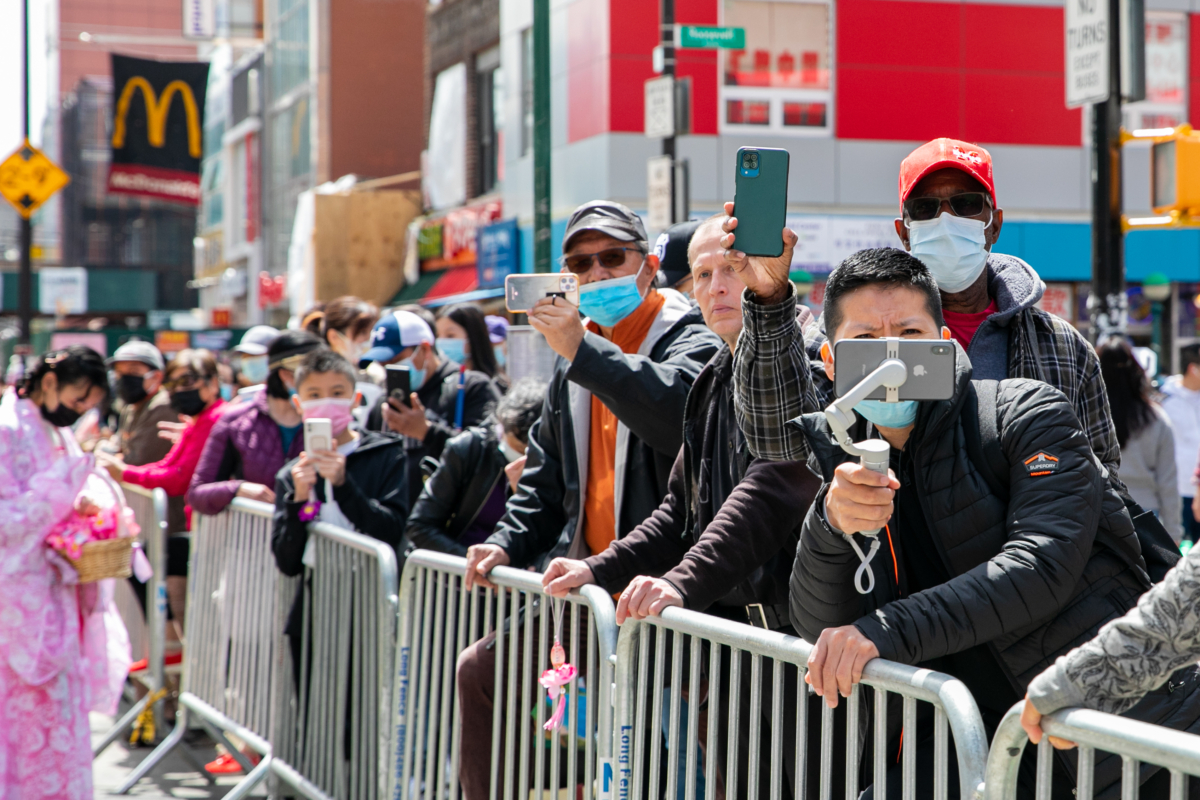 Bystanders join Falun Gong practitioners in a parade to commemorate the 23rd anniversary of the April 25th peaceful appeal of 10,000 Falun Gong practitioners in Beijing, in Flushing, New York, on April 23, 2022. (Chung I Ho/The Epoch Times)