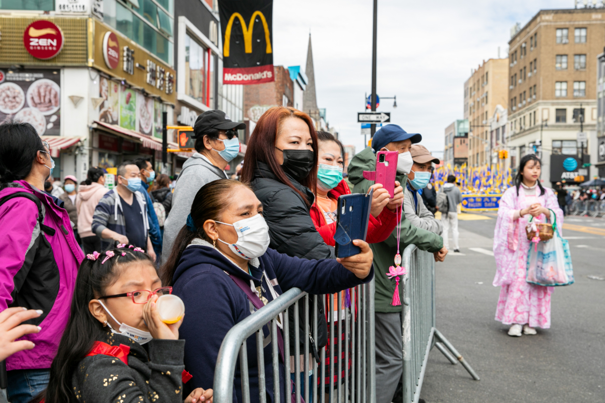 Bystanders join Falun Gong practitioners in a parade to commemorate the 23rd anniversary of the April 25th peaceful appeal of 10,000 Falun Gong practitioners in Beijing, in Flushing, New York, on April 23, 2022. (Chung I Ho/The Epoch Times)