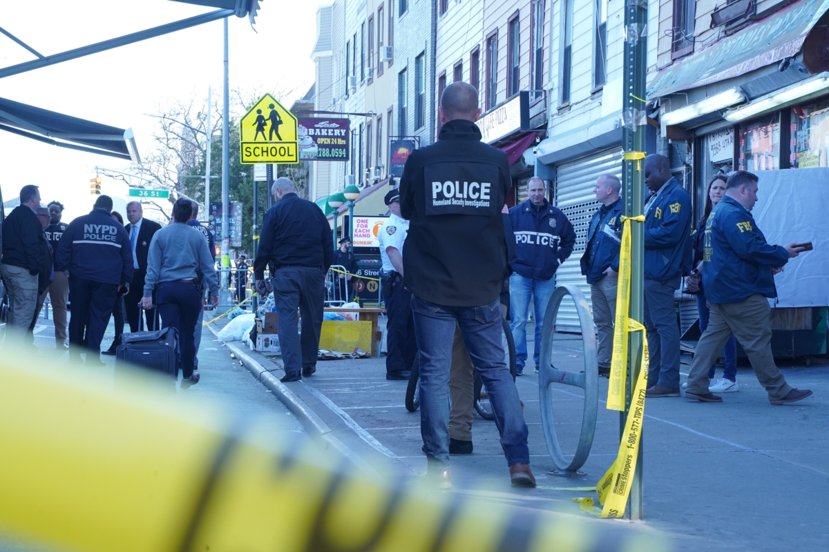 Officers investigate a shooting at the 36th Street subway station in Brooklyn, New York, on April 12, 2022. (Enrico Trigoso/The Epoch Times)