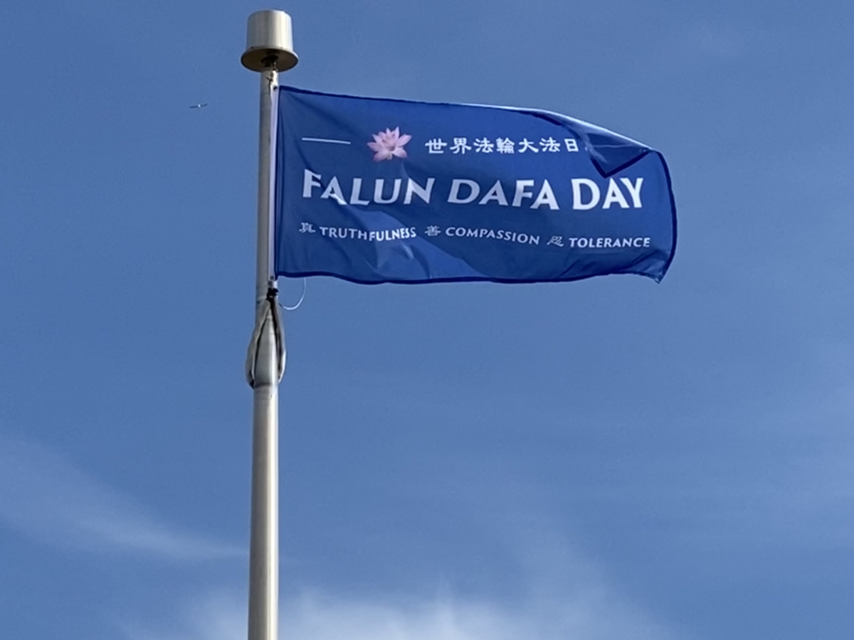 A "Falun Dafa Day" flag sways in the air after being raised by the Niagara Falls City Council ahead of World Falun Dafa Day in Niagara Falls, Canada, on May 8, 2021. (The Epoch Times)
