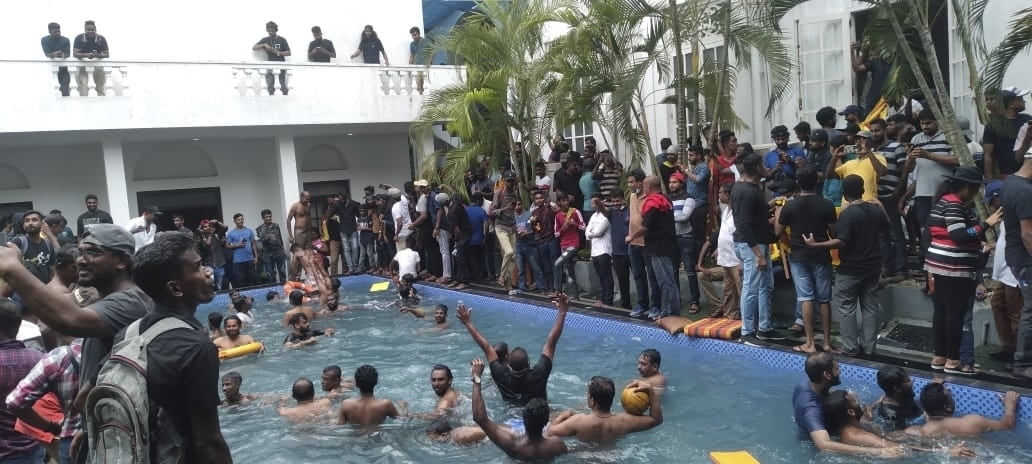 Protesters swim in a swimming pool of the Sri Lankan president's official residence after storming into it in Colombo, Sri Lanka, on July 9, 2022. (AP Photo)