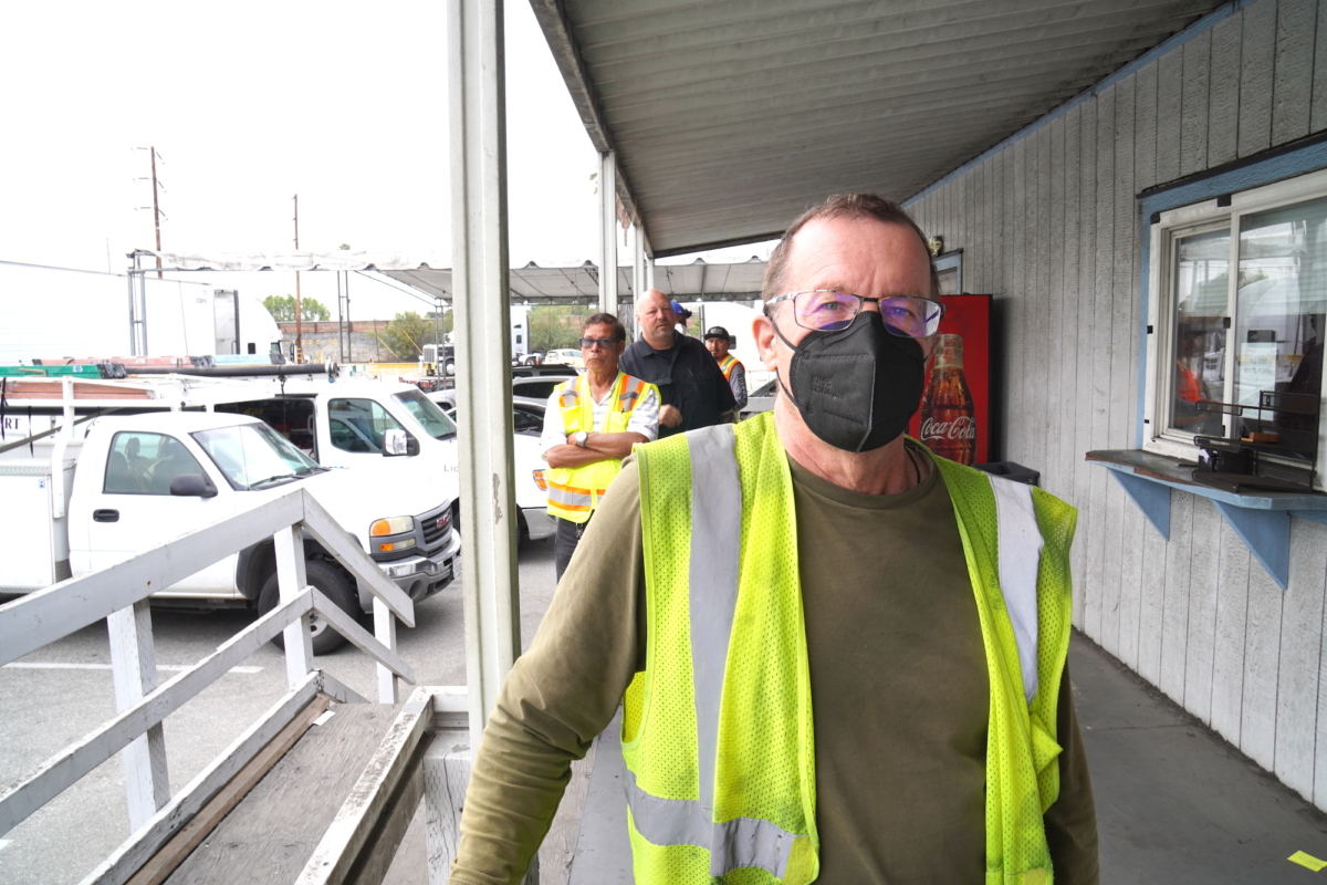 Michael Clifford, a company truck driver from Utah, waits in line for his entry papers at a transportation logistics company in Long Beach on July 26, 2022. Clifford said he thinks California's new state labor law redefining owner-operators as employees will hurt the industry long term. (Allan Stein/The Epoch Times)