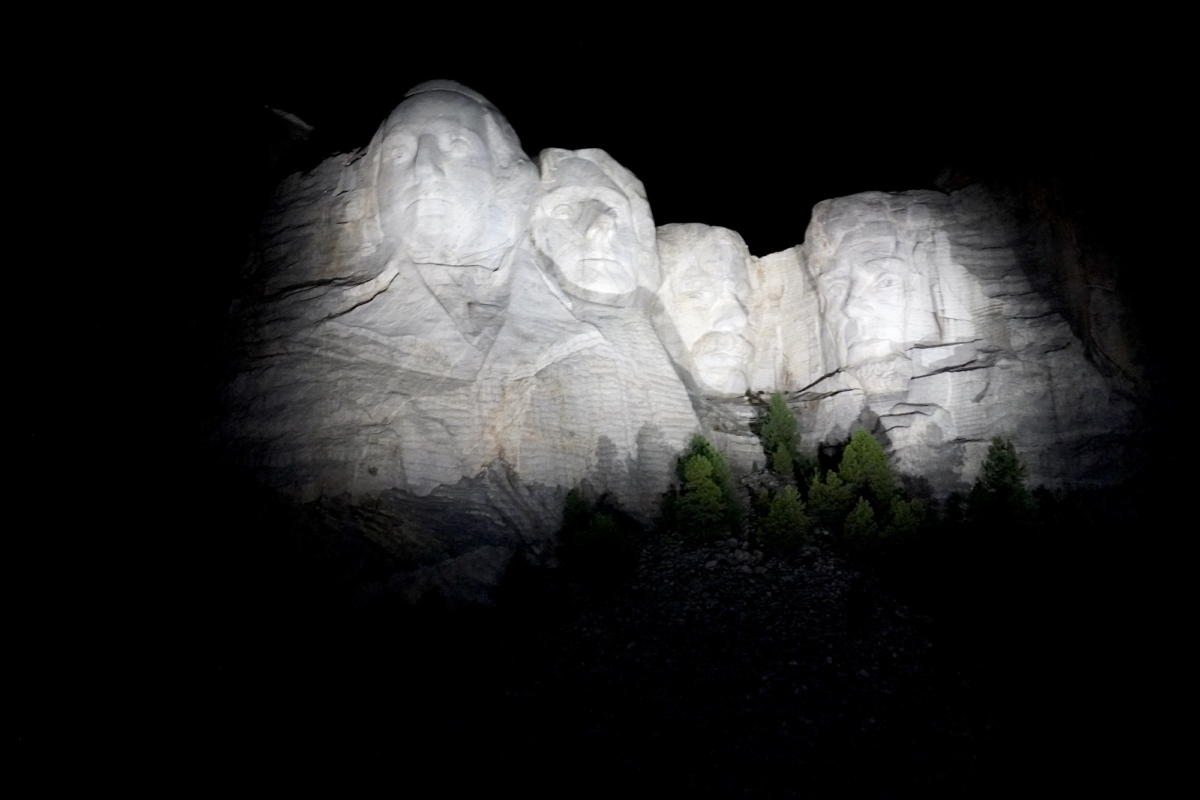 A ghostly glow envelops Mount Rushmore during a nighttime program in Keystone, S.D., on Sept. 7, 2022. (Allan Stein/The Epoch Times)
